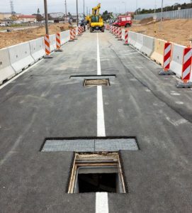 Construction site showing minimal surface disruption with small access points for sewer repair